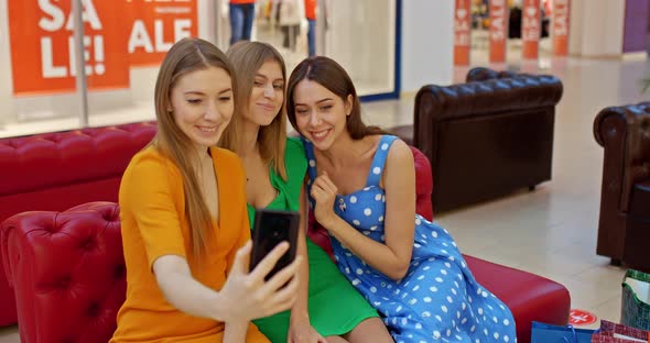 Portrait Girlfriends Take a Selfie in the Supermarket Smile at the Phone Camera and Wave alt