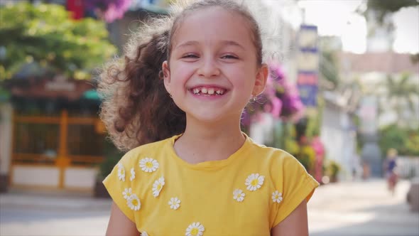 Portrait Cute Little Child Smilling on the Sunset in City Park. alt