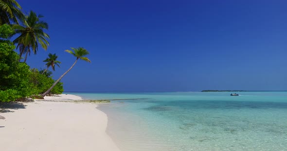 Daytime overhead travel shot of a white sandy paradise beach and aqua blue water background in 4K alt