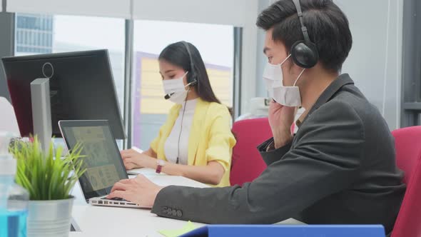 Group of Asian business call center people wear face mask and working in office with new normal. alt