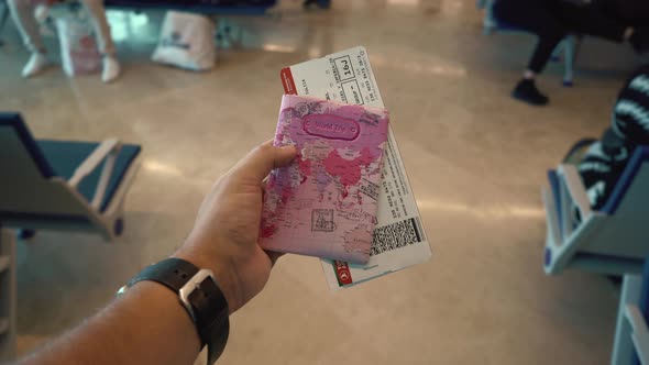 Closeup Male Hand Holding Airline Boarding Pass Tickets and Passport