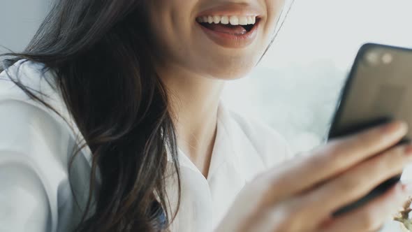 Close-up of Woman Smile with Arm Holding Phone and Arm Holding Fok with Salad alt