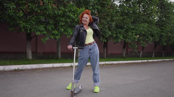 Happy Confident Beautiful Retro Woman with Kick Scooter Standing on Street Road Laughing Looking at alt