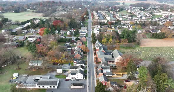 Descending aerial of rural town in USA. American village with houses and homes in autumn fall scene. alt