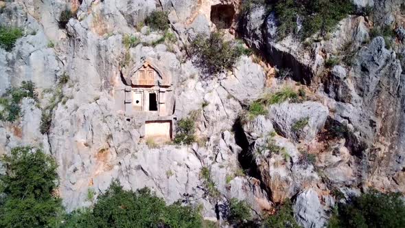 High angle drone aerial view of ancient greek rock cut lykian empire tombs in Myra (Demre, Turkey)