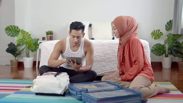 Young muslim couple preparing checking trip and suitcase for travel