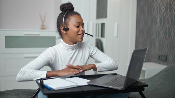 Distance Learning and Homeschooling Online African Teen Girl Uses a Laptop and Screen Tablet to alt