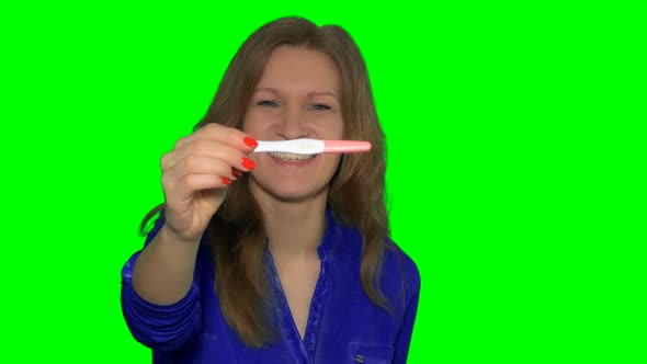 Smiling Woman Holding Positive Pregnancy Test and Show It To Camera