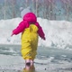 Toddler walk through puddles in the spring in a yellow rubber jumpsuit. - VideoHive Item for Sale