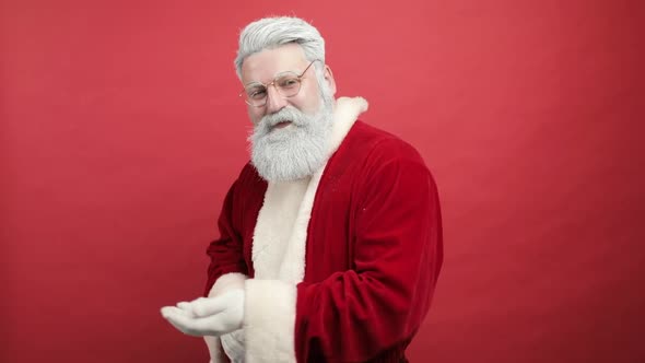 Slow Motion Stylish Cheerful Joyful Happy Bearded Man in Santa Claus Clothing Smiling and Blowing alt