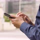A Man Works on a Smartphone in an Urban Area  Closeup  a Street in the Blurry Background - VideoHive Item for Sale