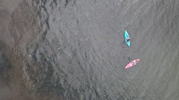 Aerial bird's eye view over tourists kayaking in the lake at daytime. alt