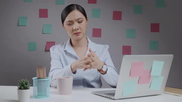 Asian woman working on a laptop was sick with body pain sitting