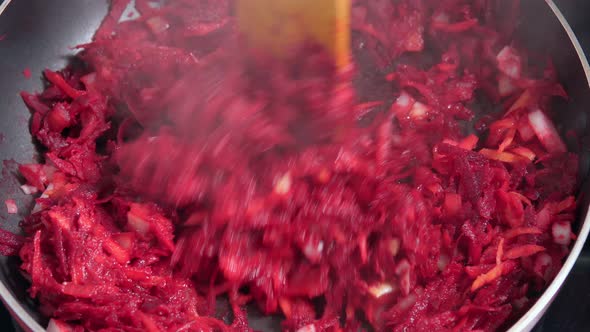 Cook Mixes Chopped Onion Grated Beetroot and Tomatoes in Pan alt