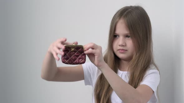 Little Girl Putting Coins Into Wallet alt