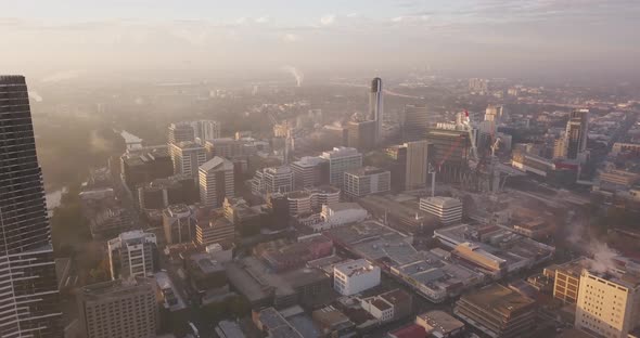 Fog and Mist Over City Centre During Sunrise alt