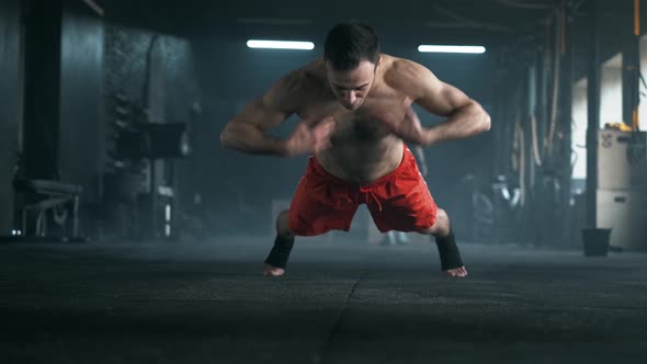 Athlete with a Beautiful Body and a Naked Torso Doing Push-ups Exercise on the Floor at the Gym alt
