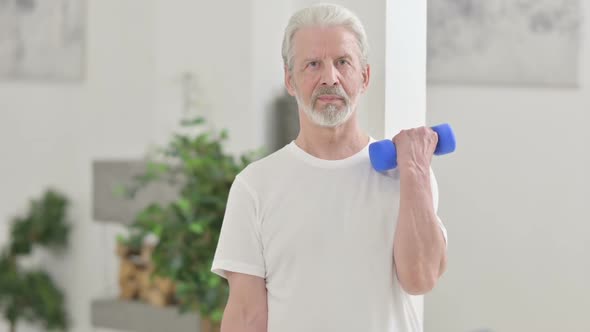 Close Up of Old Man Working Out with Dumbbells at Home alt