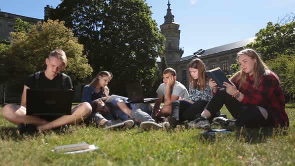 Young Exhausted Students Learning on Campus Lawn alt