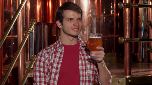 Happy Male Brewer Smelling Aromatic Fresh Delicious Beer at His Brewery alt