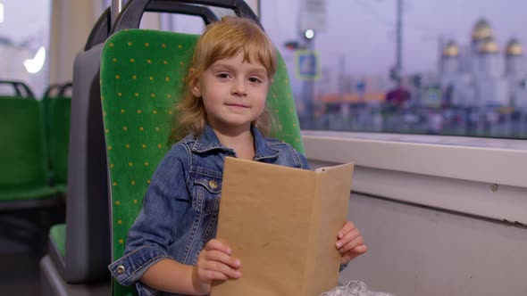 Portrait of Attractive Little Child Girl Kid Sitting at Empty Subway Train Reading Interesting Book alt