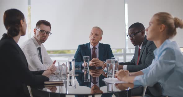 Business Leader Holding Corporate Meeting with Team in Boardroom alt