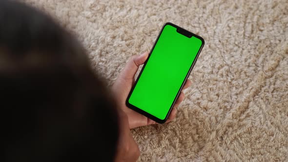 Top View Closeup View of Mobile Phone in Girls Hands with Green Mockup Screen Chroma Key Mockup or alt
