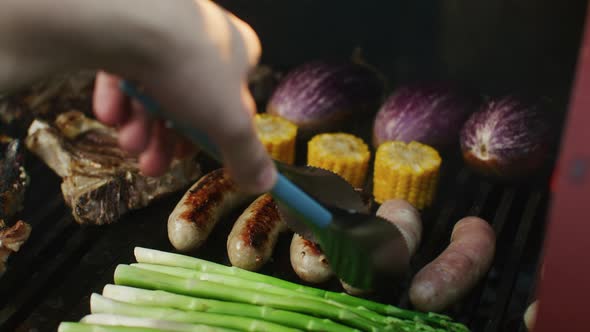 Steaks and Fresh Asparagus with Corn Grilled on the Barbecue in the Flames