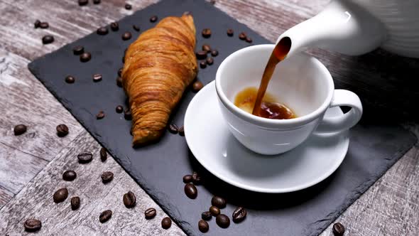 Serving a Cup of Coffee with a Croissant on a Black Board alt