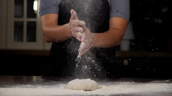 A Baker is Clapping His Hands Filled with Flour in Slow Motion