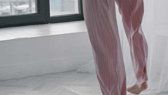 A Young Inspired Woman Dances and Wraps Herself in a Sweater alt