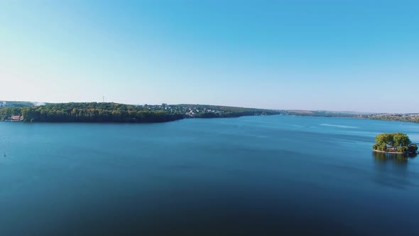 Amazing view of a blue river near the city. Wide calm river under the blue sky on the town landscape alt