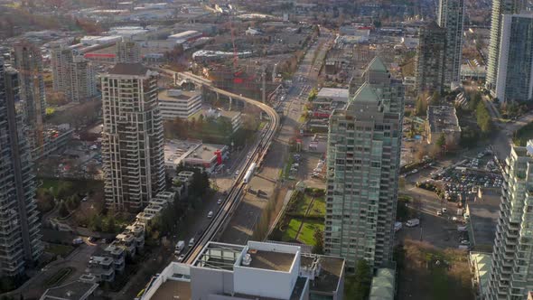 Vancouver Skytrain Moving Past Brentwood Station In Burnaby Canada- aerial shot alt