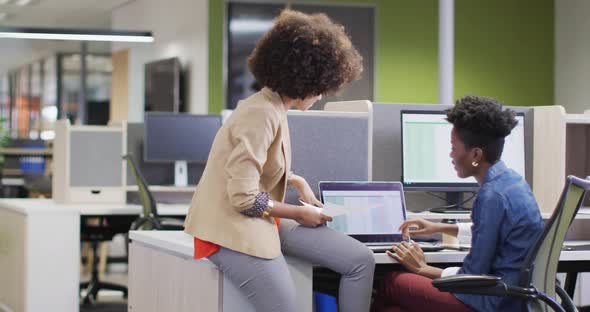 Video of diverse businesswomen working on project and using laptop alt