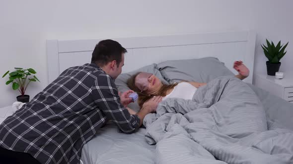 Loving Boyfriend Wakes Up His Sleeping Girlfriend Proposes to Her and Presents Small Box with Ring alt