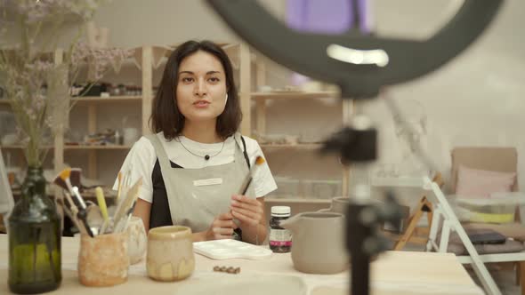 Female Potter Recording Vlog in Workshop