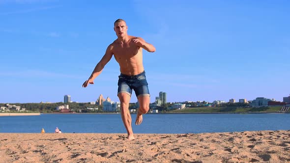 Young Man Doing Sports Exercises at the Beach While Sunny Summer Day alt