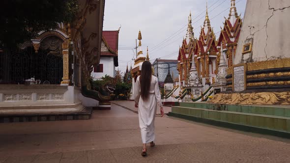 Beautiful woman tourist walking in Buddhist Wat Luang Temple, Pakse, Laos. 4K Slow. Asian culture