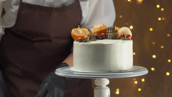 Closeup of a Chief's Hand Decorating the Chocolate Cake with Cheese Souffle alt