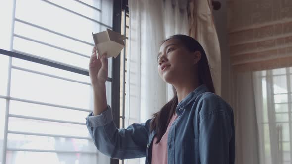 Attractive portrait young Asian woman freelance architect holding a model of home.