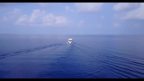 Aerial drone scenery of idyllic coast beach trip by blue ocean and white sand background of journey  alt