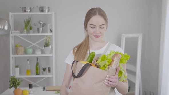 Middle Shot of Young Pretty Girl Posing with Grocery Bag at Home alt