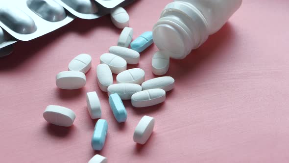 Close Up of Colorful Pills Spilling From Container  alt