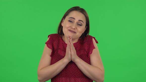 Portrait of Tender Girl in Red Dress Is Showing Disgust for Bad Smell or Taste. Green Screen alt