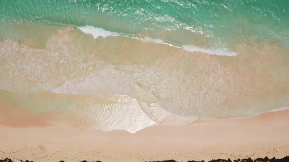 Aerial Top View of Sea Blue Waves Break on a Beach