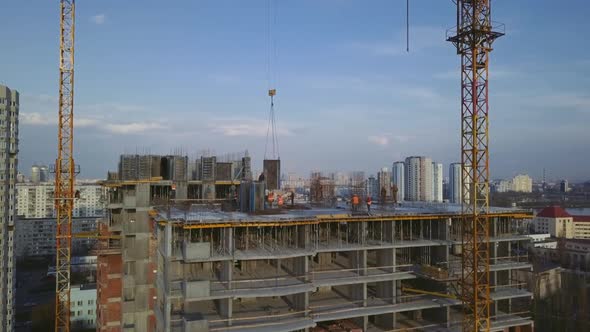 Workers on a Highrise Building in the Evening Clog the Formwork for Pouring Concrete