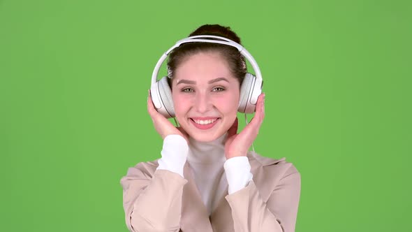 Woman Listens To Melodious Songs in the Headphones. Green Screen. Slow Motion alt