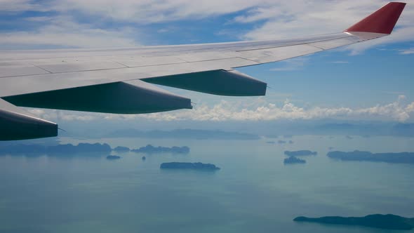 View From The Window Of An Airplane Flying Over The Sea With Tropical Islands alt