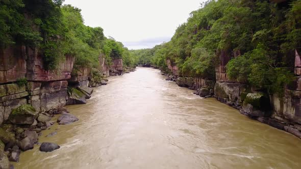 Aerial shot flying over Caño Cristales river in a Colombian nature reserve alt