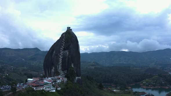 Aerial rising up in front of La pietra, Guatape during evening. Drone 4k. alt